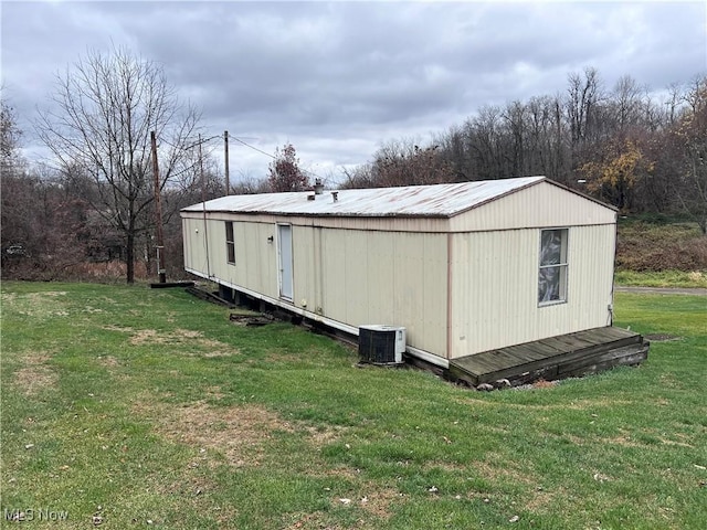 view of outbuilding with central AC and a lawn