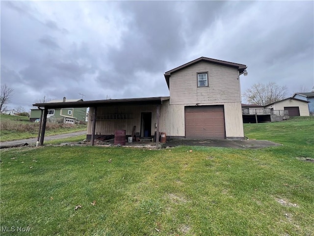 rear view of property with a garage and a yard