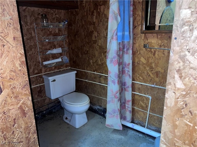 bathroom featuring concrete floors and toilet