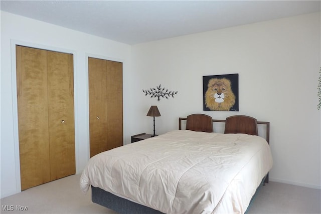 carpeted bedroom featuring multiple closets