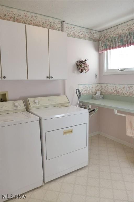 laundry area with independent washer and dryer and cabinets