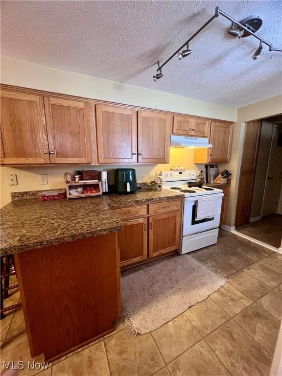 kitchen featuring a breakfast bar area, a textured ceiling, and white range with electric cooktop