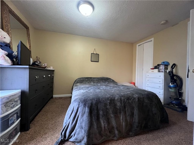 bedroom with a textured ceiling and dark carpet