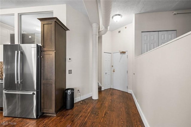 corridor with stairway, baseboards, dark wood-style flooring, and a textured ceiling