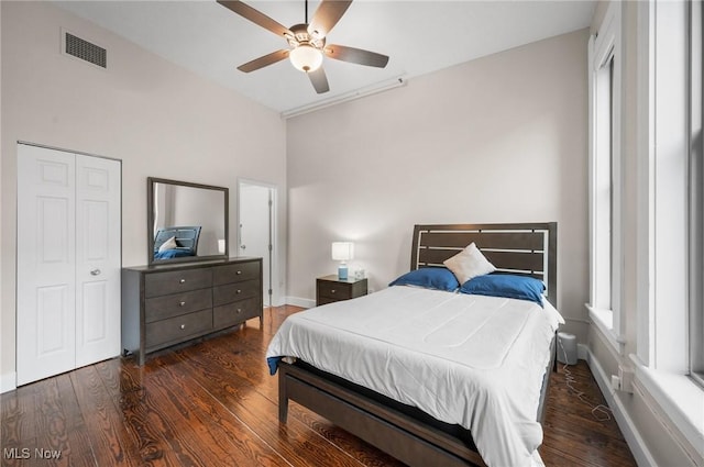 bedroom featuring multiple windows, dark hardwood / wood-style floors, and ceiling fan