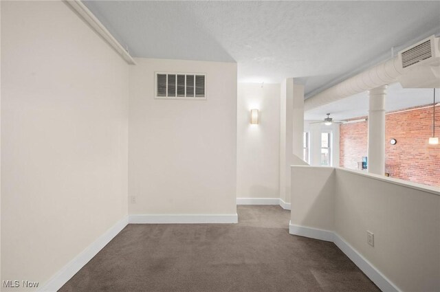 carpeted spare room with a textured ceiling