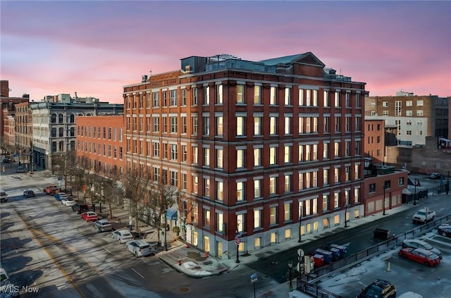 property at dusk with a city view