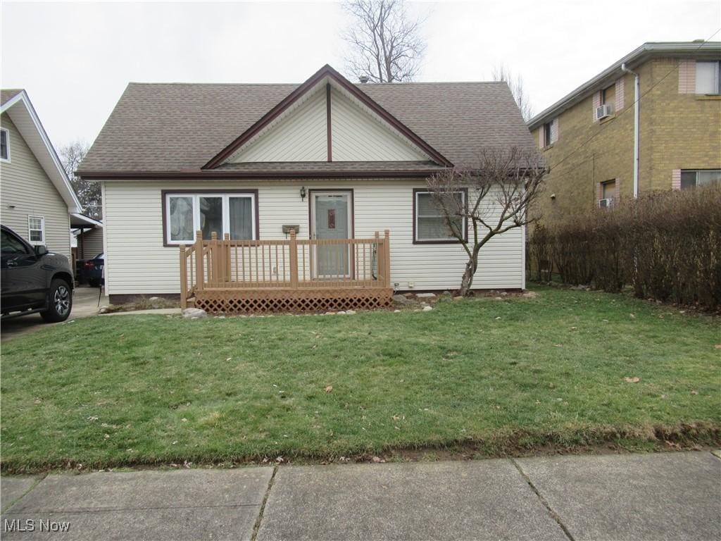 view of front facade with a wooden deck and a front lawn