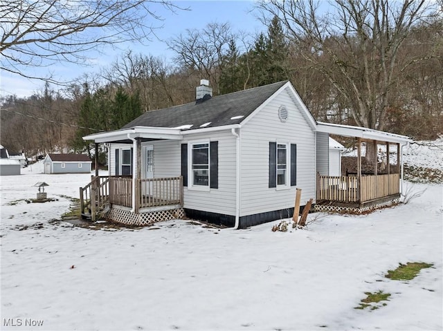 snow covered house featuring a deck