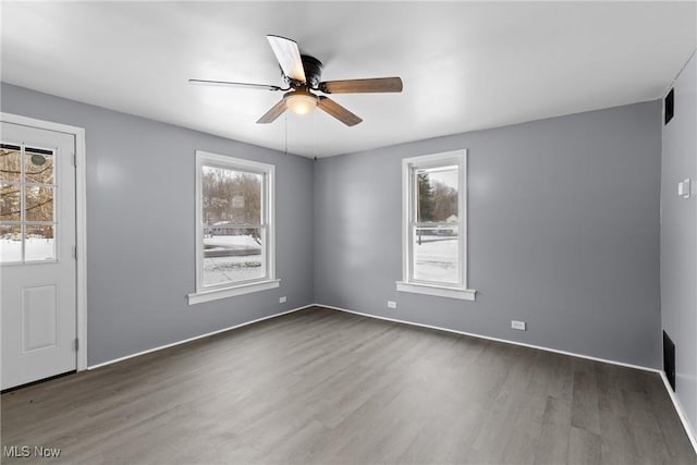 unfurnished room with dark wood-type flooring and ceiling fan