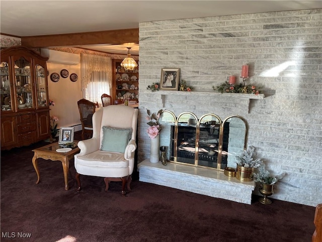 sitting room featuring a wall mounted air conditioner, a fireplace, beamed ceiling, and dark colored carpet