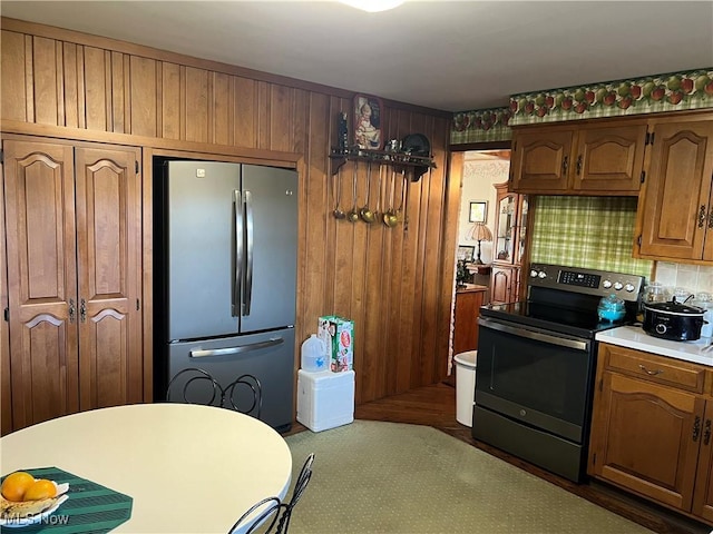 kitchen featuring stainless steel appliances and wood walls