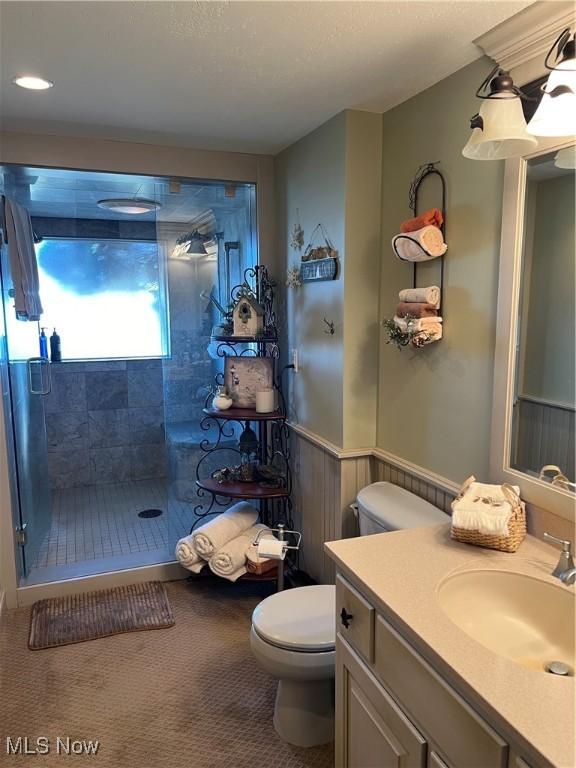 bathroom with vanity, toilet, and a tile shower