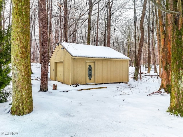 snow covered structure with a garage