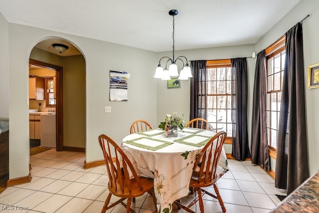 dining area with light tile patterned floors, a notable chandelier, and sink