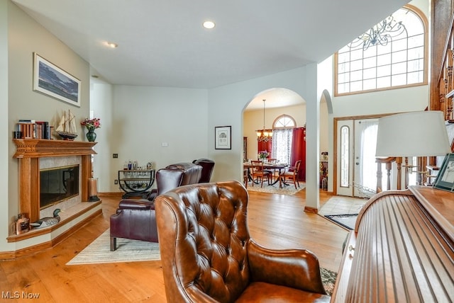 living room featuring a chandelier, a fireplace, and light hardwood / wood-style flooring