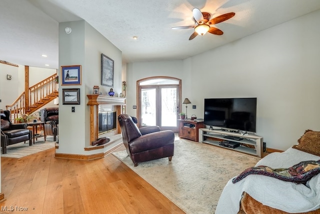 living room with ceiling fan, wood-type flooring, and a textured ceiling