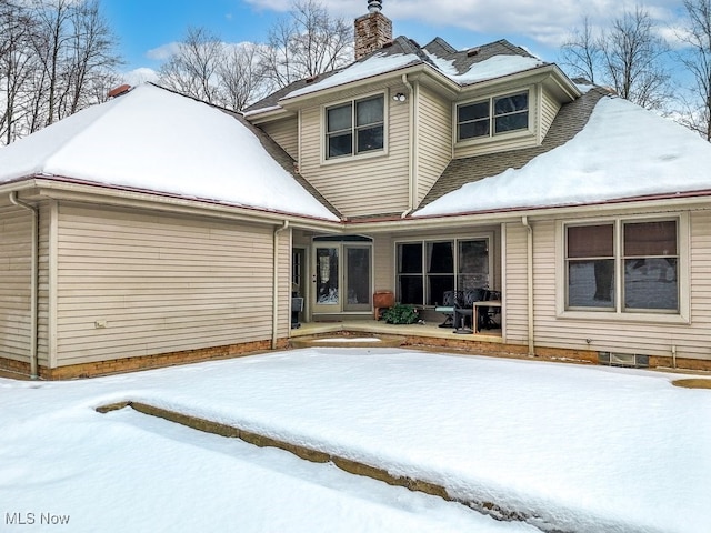 view of snow covered back of property