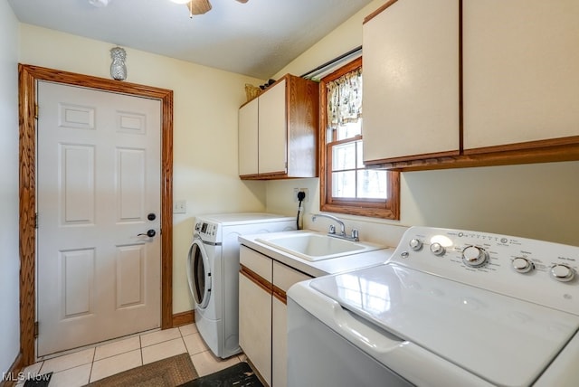 laundry room featuring sink, light tile patterned floors, ceiling fan, cabinets, and washing machine and clothes dryer