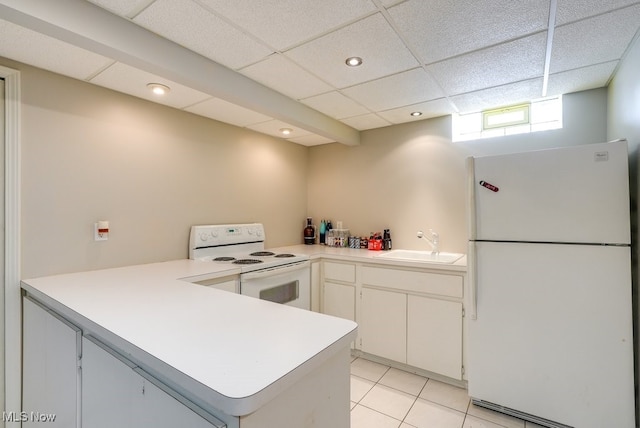 kitchen featuring sink, white appliances, a paneled ceiling, white cabinetry, and kitchen peninsula