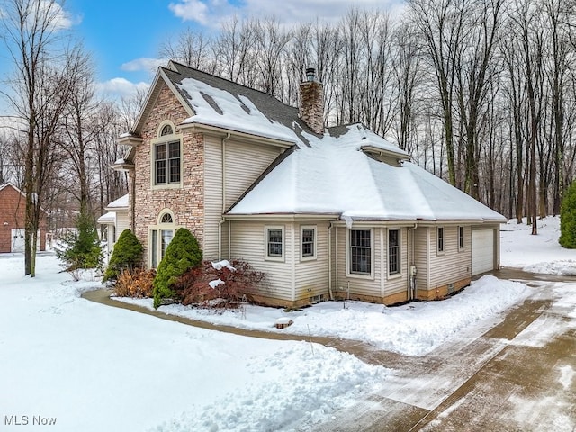 view of snow covered exterior with a garage