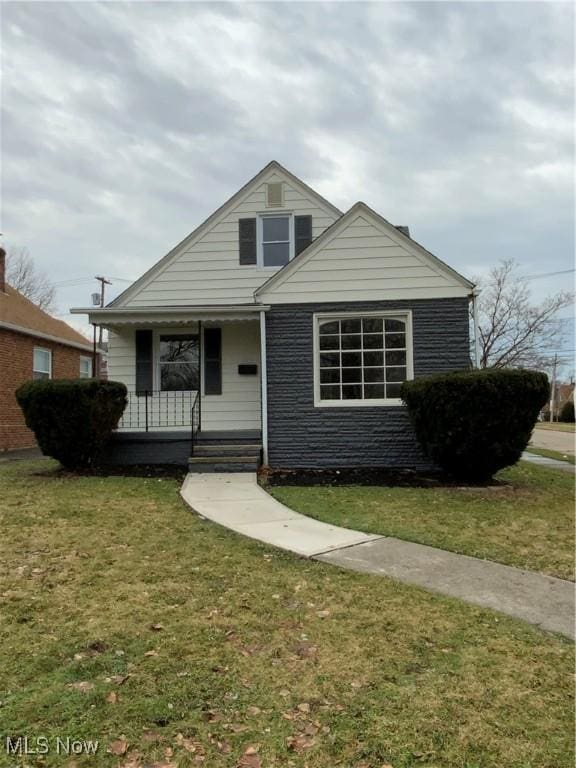 view of front of home with covered porch and a front lawn