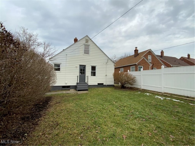 rear view of property with a yard