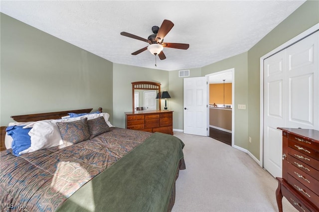 carpeted bedroom featuring a textured ceiling and ceiling fan