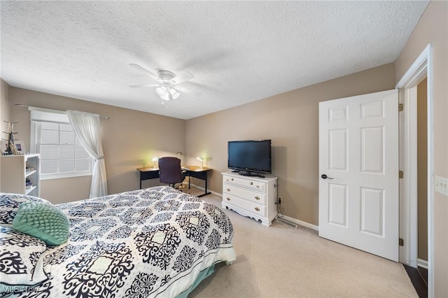 carpeted bedroom with ceiling fan and a textured ceiling