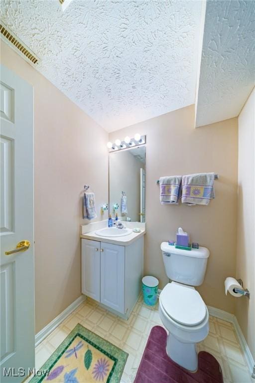 bathroom featuring vanity, toilet, and a textured ceiling