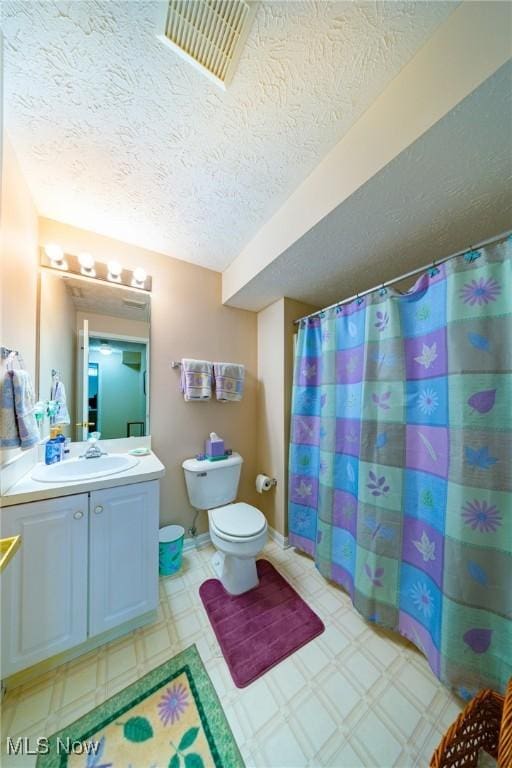 bathroom with vanity, a textured ceiling, a shower with curtain, and toilet