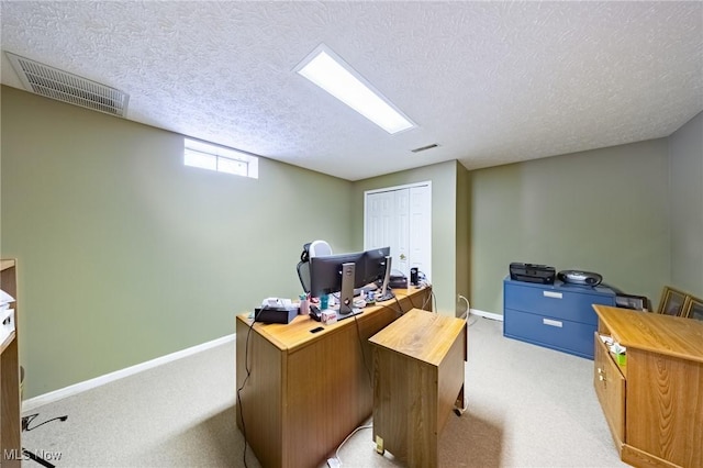 office with light colored carpet and a textured ceiling