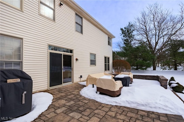 snow covered patio featuring a grill