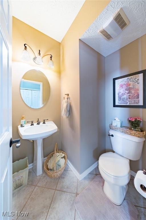 bathroom featuring sink, a textured ceiling, tile patterned floors, and toilet