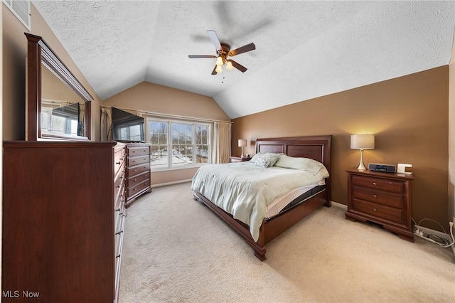 bedroom with multiple windows, vaulted ceiling, light carpet, and a textured ceiling