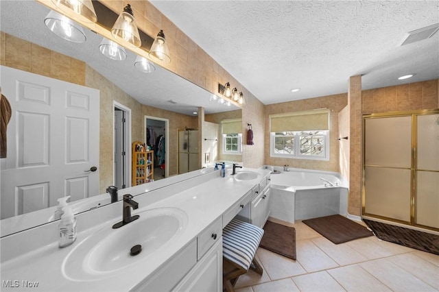 bathroom featuring shower with separate bathtub, tile patterned floors, a textured ceiling, and vanity