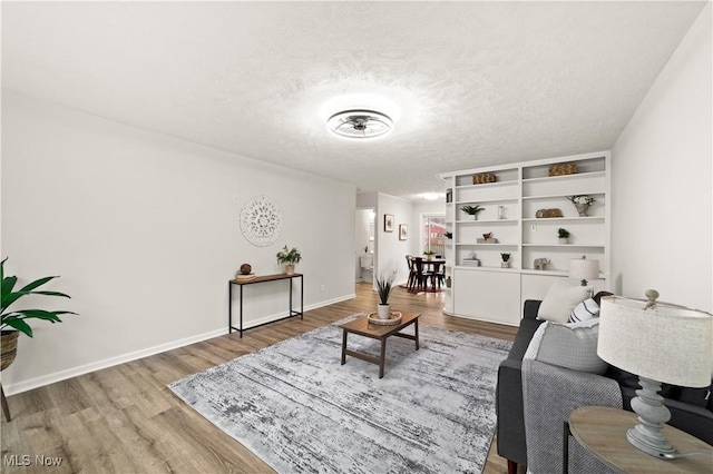 living room featuring wood-type flooring and a textured ceiling