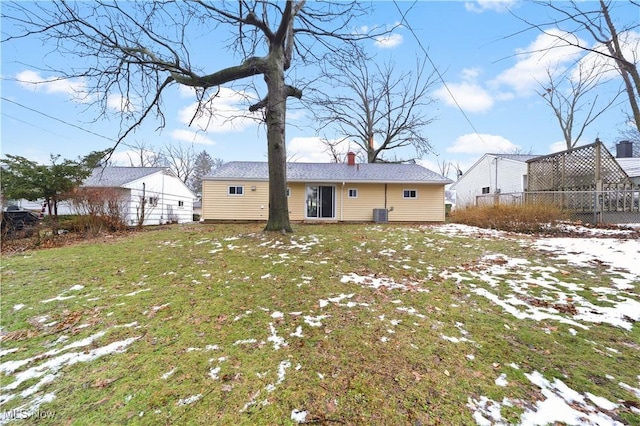 snow covered house with central air condition unit and a lawn