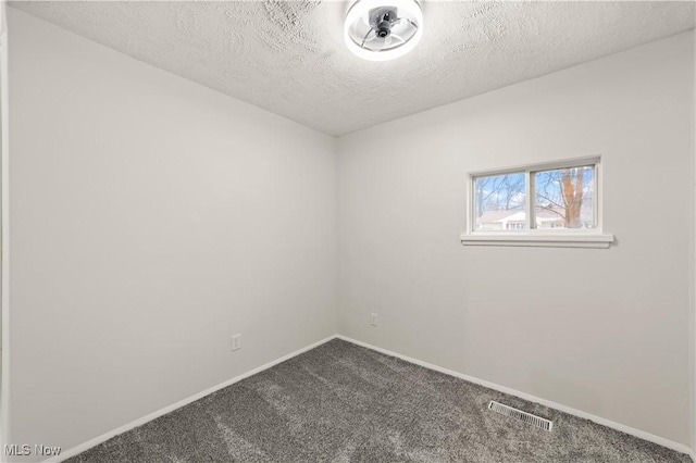 carpeted spare room featuring a textured ceiling