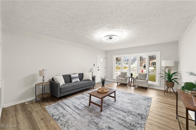 living room with hardwood / wood-style flooring and a textured ceiling