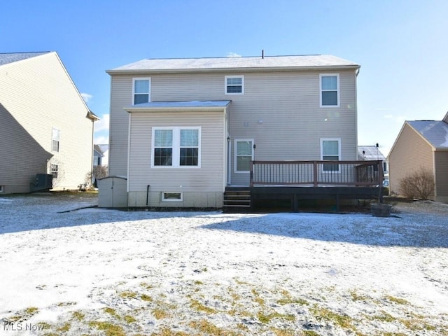 snow covered rear of property with a wooden deck