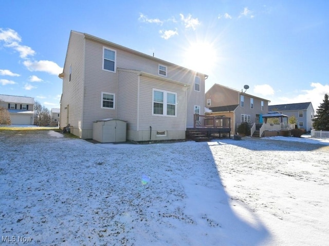 snow covered back of property featuring a gazebo and a deck