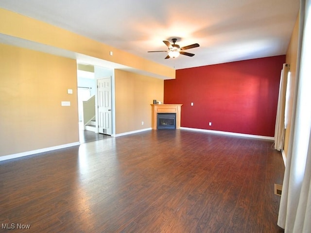 unfurnished living room featuring dark hardwood / wood-style flooring and ceiling fan