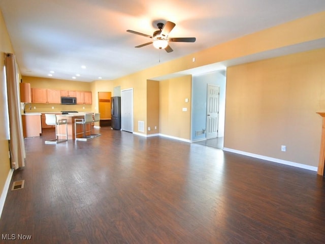 unfurnished living room with sink, dark wood-type flooring, and ceiling fan