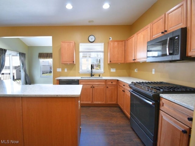 kitchen featuring light brown cabinetry, dishwasher, sink, dark hardwood / wood-style flooring, and gas range