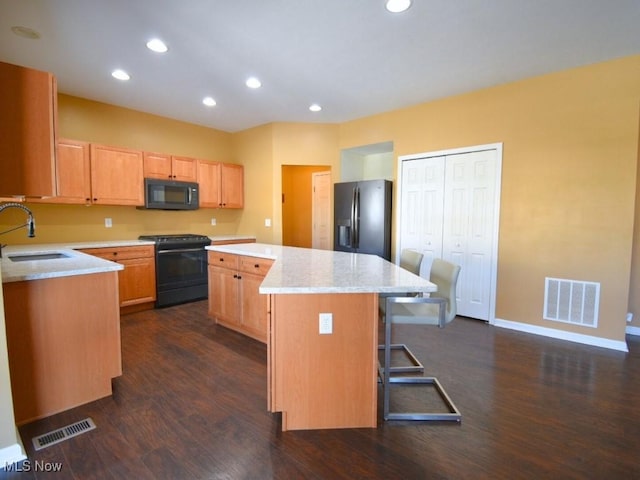 kitchen with a kitchen island, range with gas cooktop, sink, a kitchen breakfast bar, and stainless steel refrigerator with ice dispenser