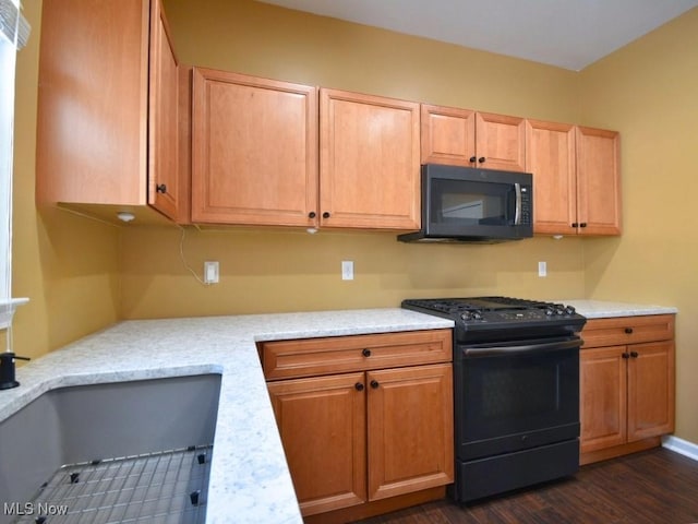 kitchen featuring dark hardwood / wood-style floors, range with gas stovetop, sink, and light stone countertops