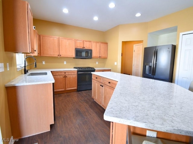 kitchen featuring light brown cabinetry, sink, a center island, black appliances, and dark wood-type flooring