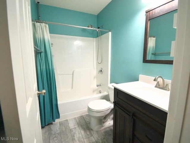 full bathroom featuring hardwood / wood-style flooring, shower / bath combo, vanity, and toilet