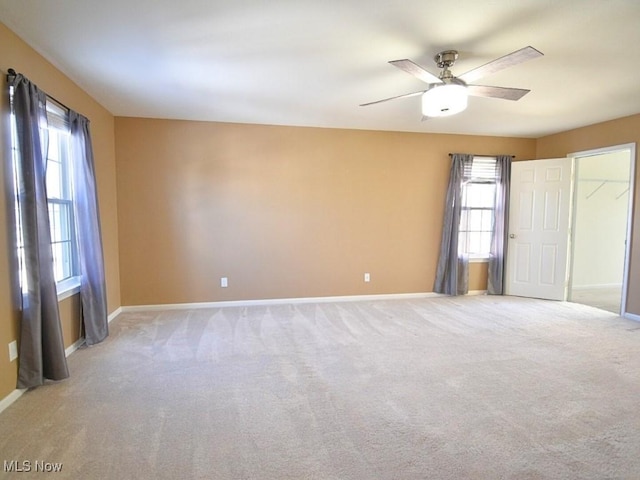 carpeted spare room with ceiling fan